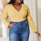 Woman wearing All About Details ribbed bodysuit with lace-up caged neck detail, paired with high-waisted jeans, posing in a room.