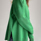 Woman wearing green turtleneck sweater with side slits and dropped shoulders, perfect blend of style and comfort for any season