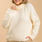 Plus size woman in a cozy cream turtle neck long sleeve sweater, perfect for winter fashion.