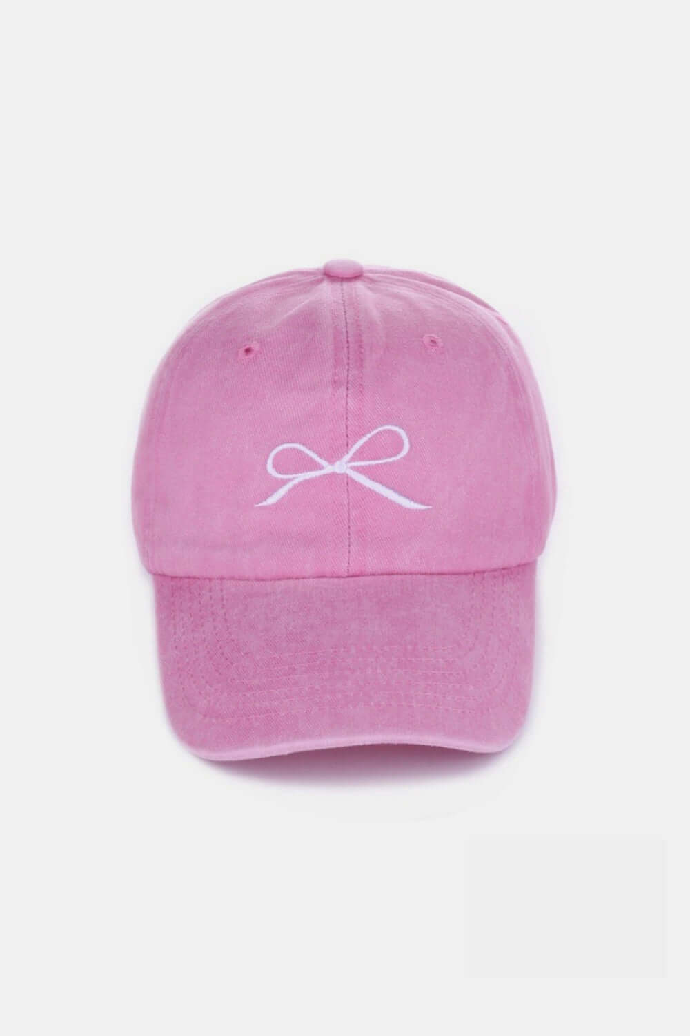 Pink bow embroidered washed cotton cap with delicate white bow design, stylish and comfortable headwear for a playful and elegant look.