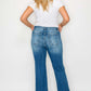 Woman showcasing bytos distressed high rise jeans from the back, highlighting their vintage style and practical pockets.