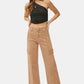 Woman wearing high-rise wide leg cargo jeans with black one-shoulder top, showcasing a stylish and trendy casual look.