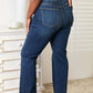 Rear view of woman wearing Judy Blue elastic waistband slim bootcut jeans in dark wash, showcasing back pocket details and fit.