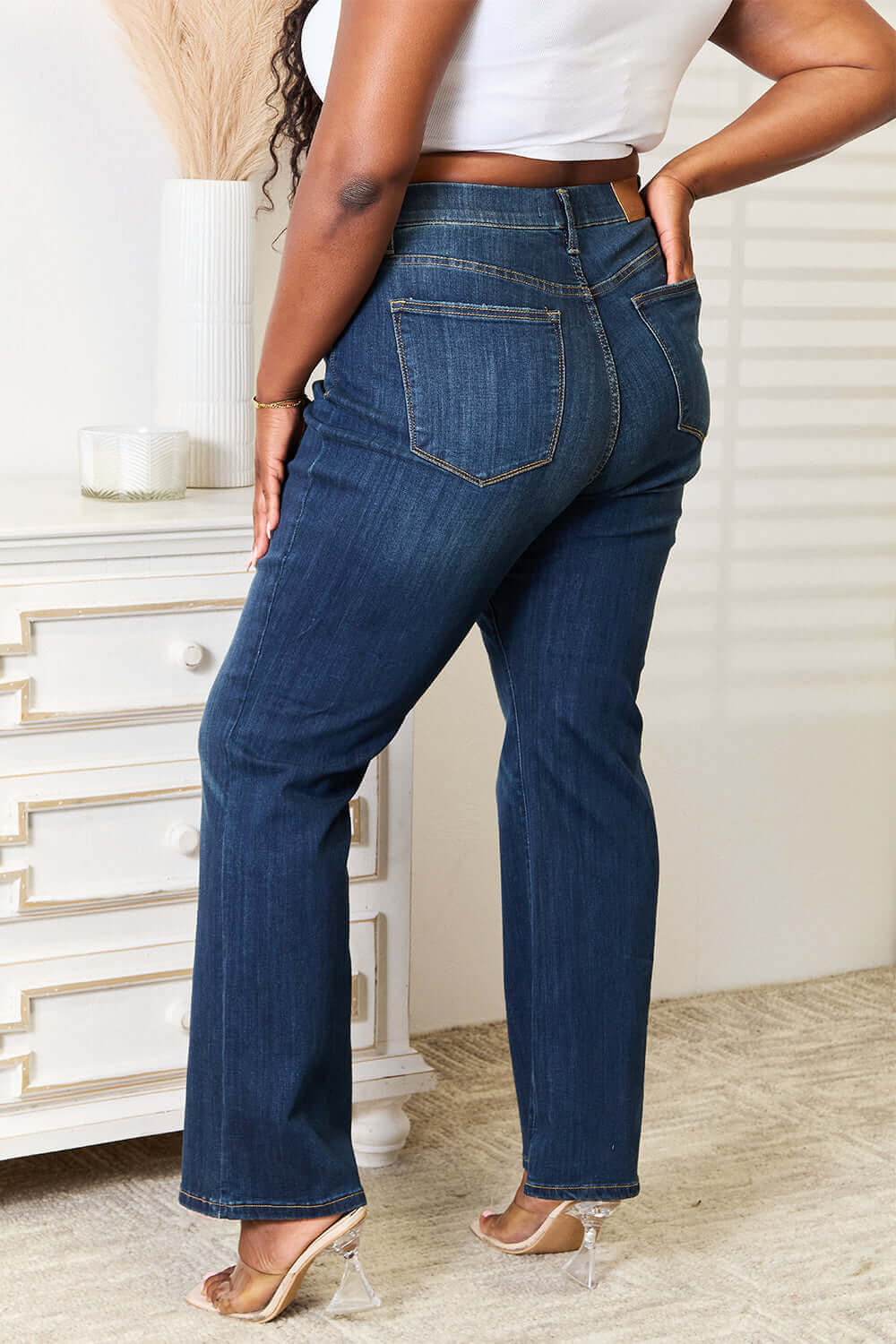 Rear view of woman wearing Judy Blue elastic waistband slim bootcut jeans in dark wash, showcasing back pocket details and fit.