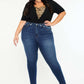 Woman modeling Kancan high-rise ankle skinny jeans with double waistband and destruction hem in dark wash for a sleek, trendy look.