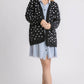 Stylish woman in a polka dot open front drop shoulder cardigan over a denim dress, perfect for layering and everyday wear.