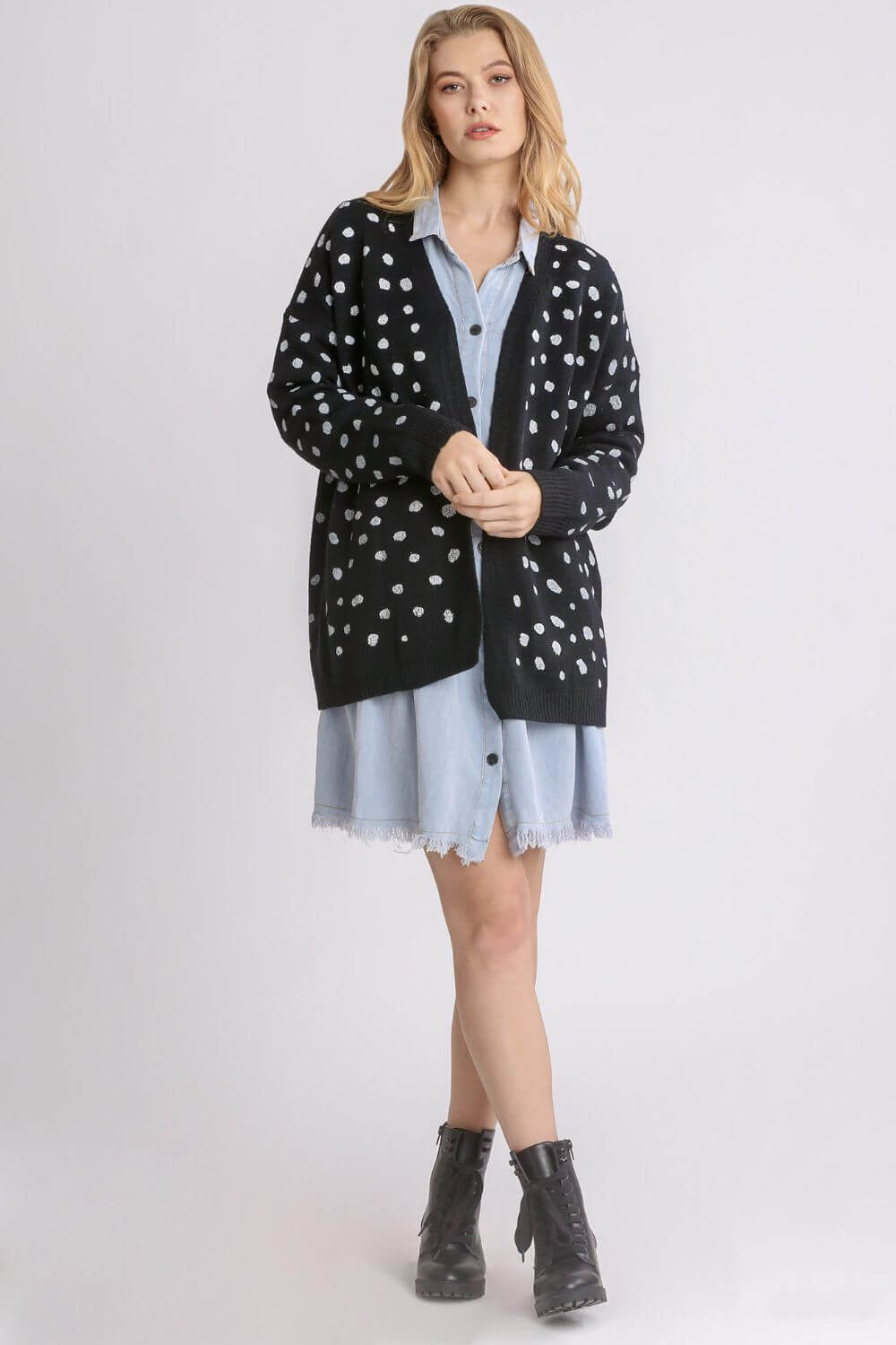 Stylish woman in a polka dot open front drop shoulder cardigan over a denim dress, perfect for layering and everyday wear.