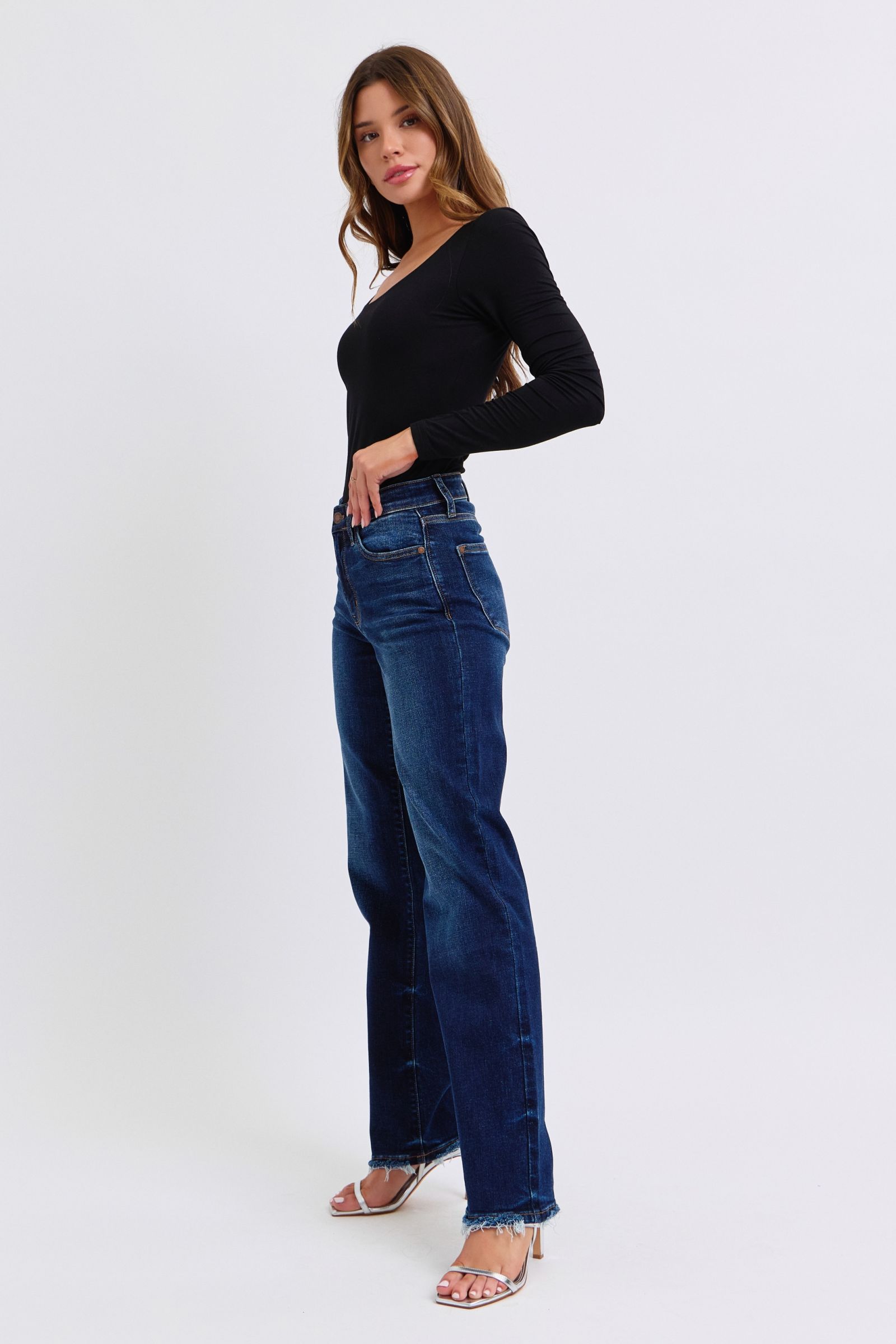 Woman wearing Judy Blue raw hem straight leg jeans and black top for a chic casual look.