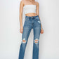 High rise distressed ankle Risen Jeans with trendy detailing and flattering fit, modeled with white crop top and clear heels.