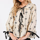 SAGE + FIG Bow Print Tie Front Babydoll Blouse with playful bow pattern and flared sleeves, perfect for chic casual looks.