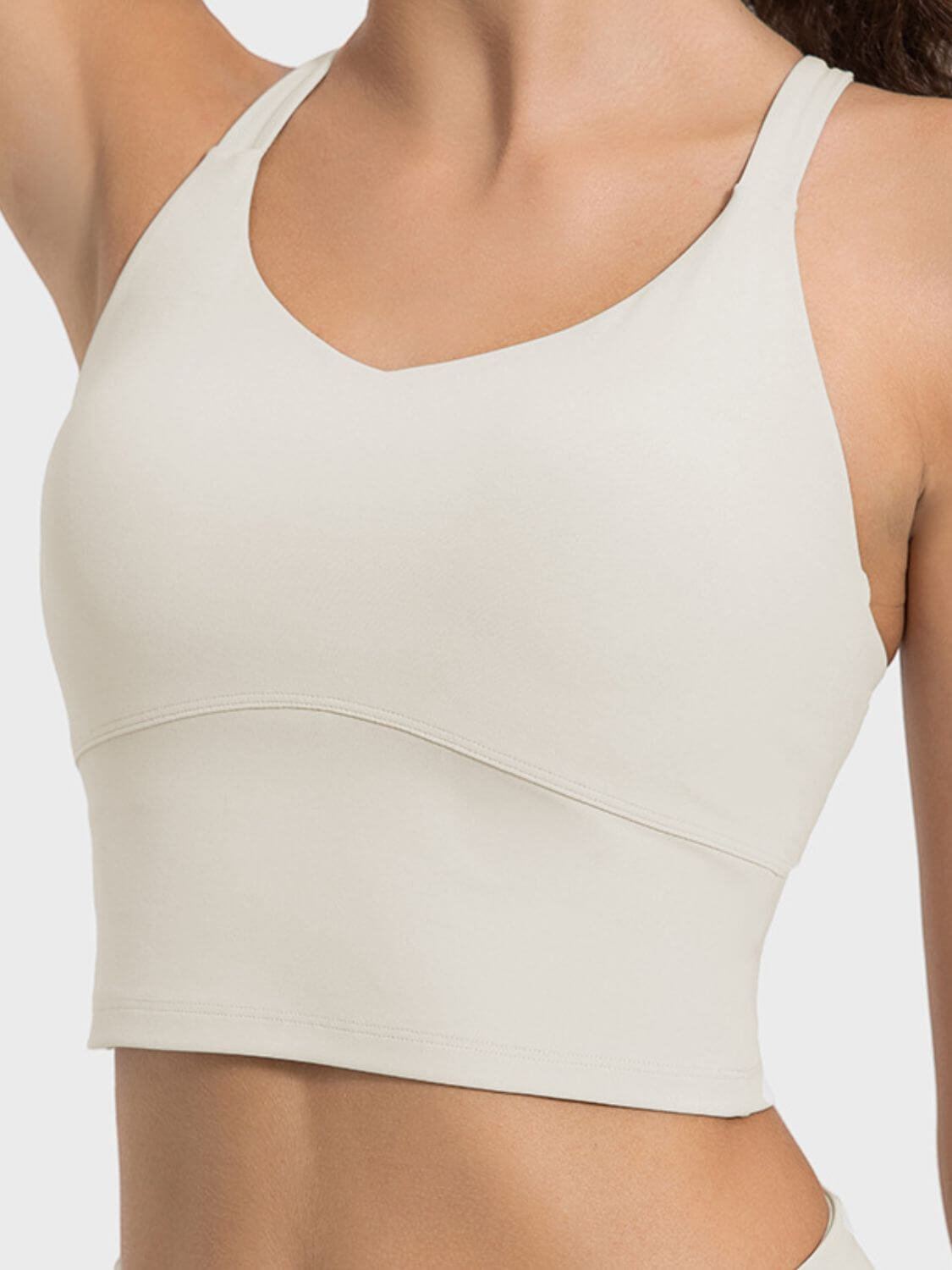 Crisscross round neck active tank in light beige, showcasing breathable fabric and modern design for active wear.