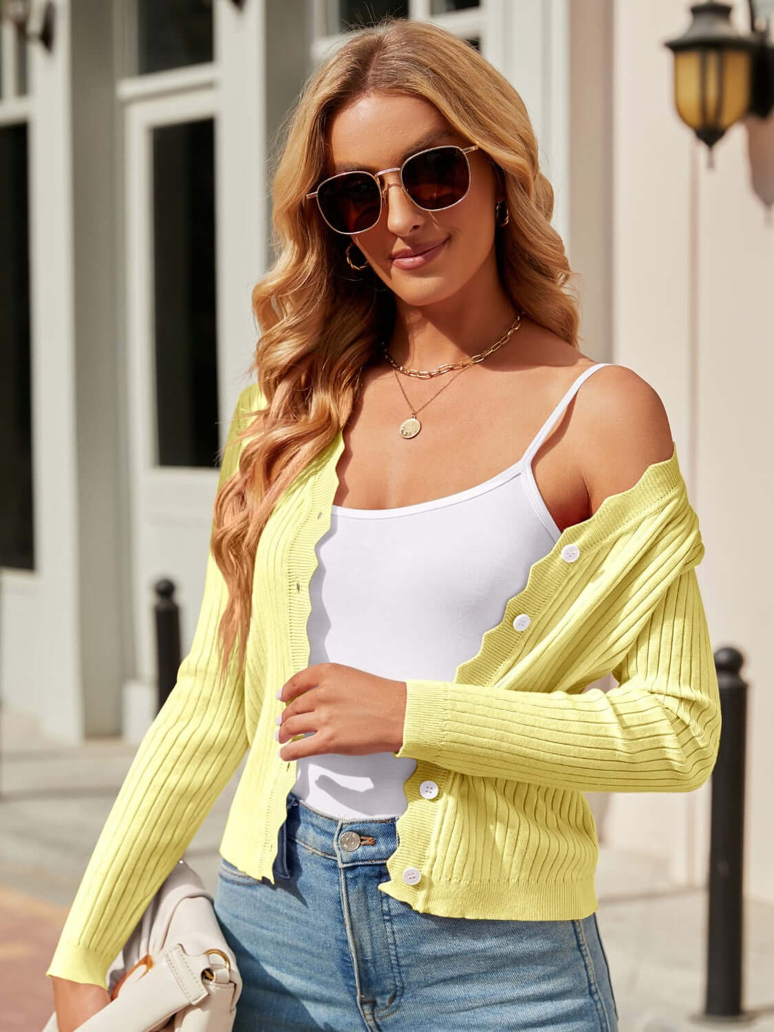 Woman wearing Bella Road Button Up Long Sleeve Cardigan in light yellow, styled with white top and jeans, accessorized with sunglasses.