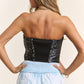 Woman wearing a J.NNA Sequin Strapless Bustier Top with shimmering sequins, showcasing a chic, fitted silhouette perfect for parties.