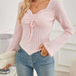 Woman wearing Bella Road Ribbed Drawstring Long Sleeve T-Shirt in light pink paired with blue jeans.