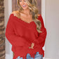 Woman wearing Bella Road frayed hem dropped shoulder sweater in red, showing off playful style with comfort.