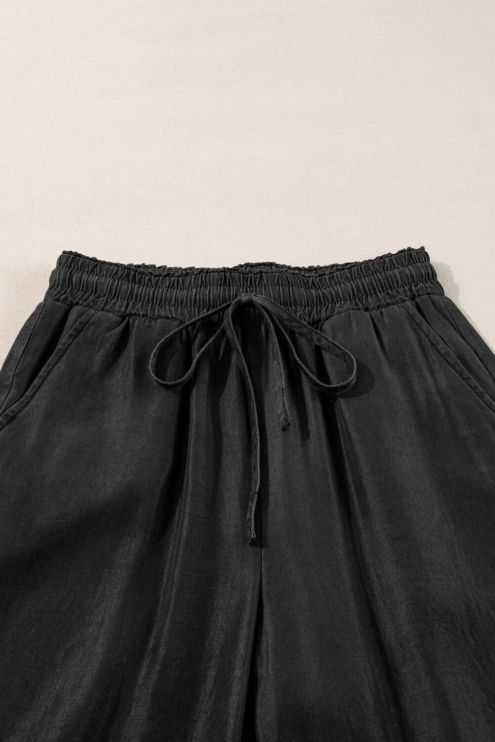 Close-up of Bella Road Drawstring Wide Leg Jeans in black showcasing the trendy drawstring waist and soft fabric.