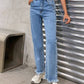 Stylish raw hem jeans with pockets, no stretch, light blue denim, perfect casual wear. Model wearing jeans with sneakers.