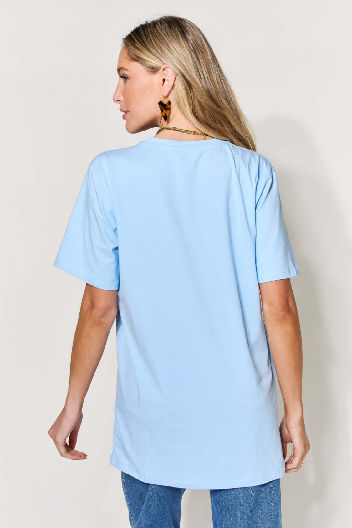 Woman wearing a light blue MAMA round neck short sleeve t-shirt, shown from the back.