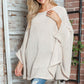 Woman wearing Bella Road Round Neck Batwing Sleeve Sweater in cozy setting, showcasing stylish design and comfort.