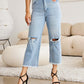 Woman wearing Tummy Control High Waist Raw Hem Distressed Jeans from RFM Jeans with a white top and black heels