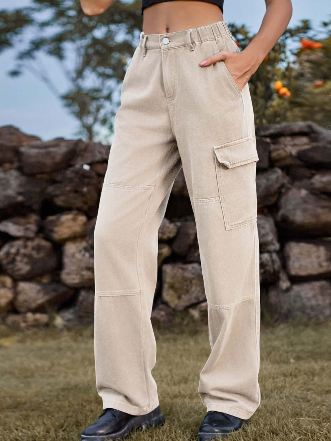 Woman wearing Bella Road High Waist Cargo Straight Jeans in beige with pockets, standing outdoors.