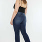 Woman wearing Kancan full size mid-rise slim flare jeans in dark stone wash, showcasing a stylish and versatile look.