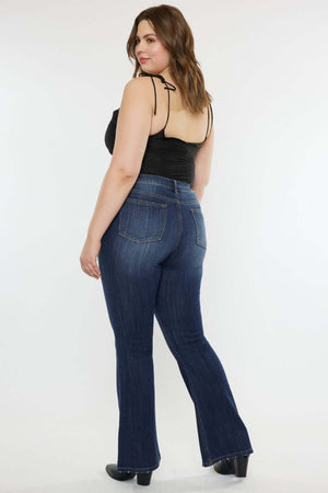 Woman wearing Kancan full size mid-rise slim flare jeans in dark stone wash, showcasing a stylish and versatile look.