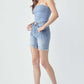 Woman wearing high rise distressed denim shorts by Risen Jeans with raw hem and slight stretch