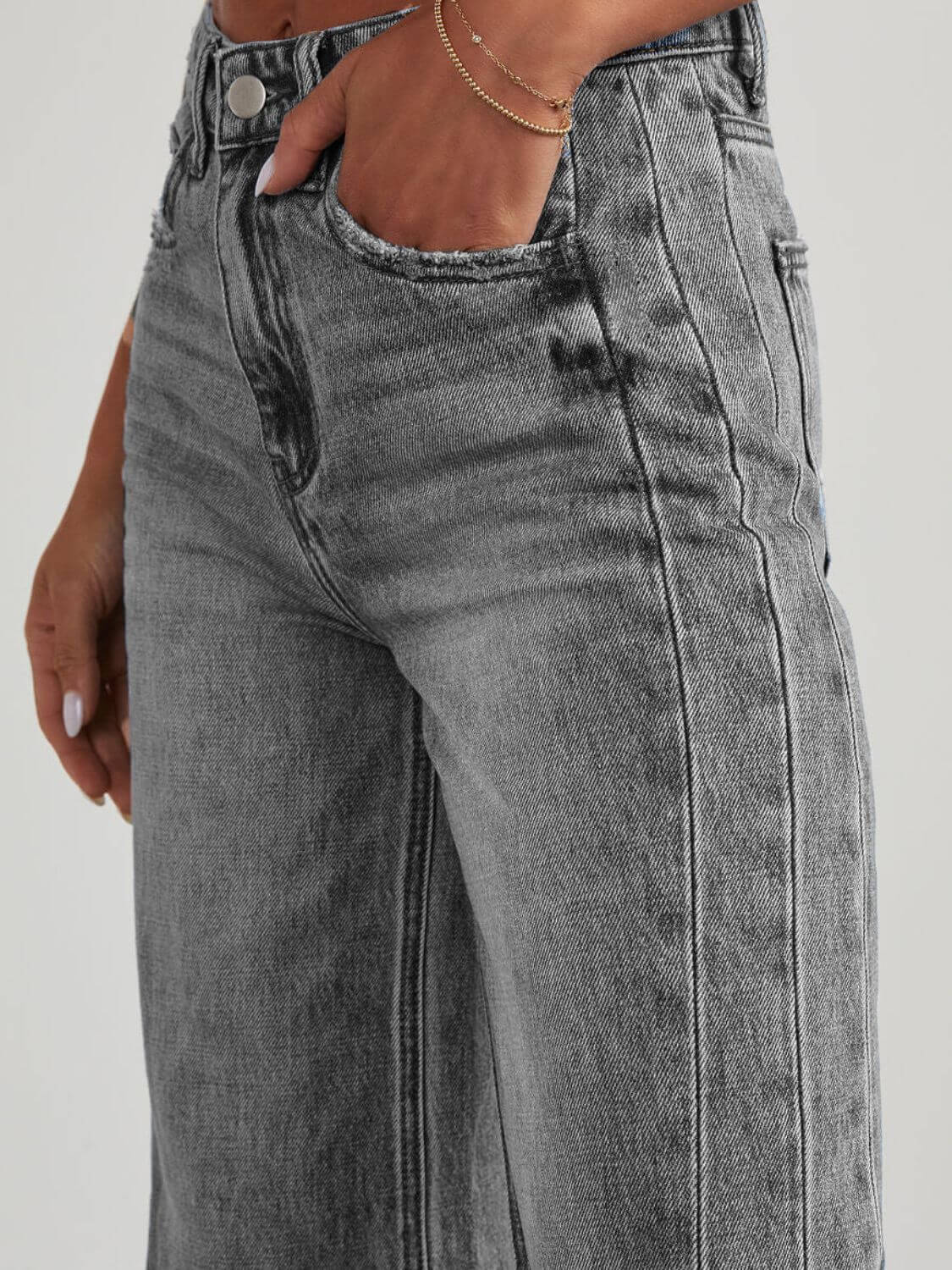 Woman wearing Bella Road Raw Hem Wide Leg Jeans with Pockets in grey, showing front button and pocket detail.