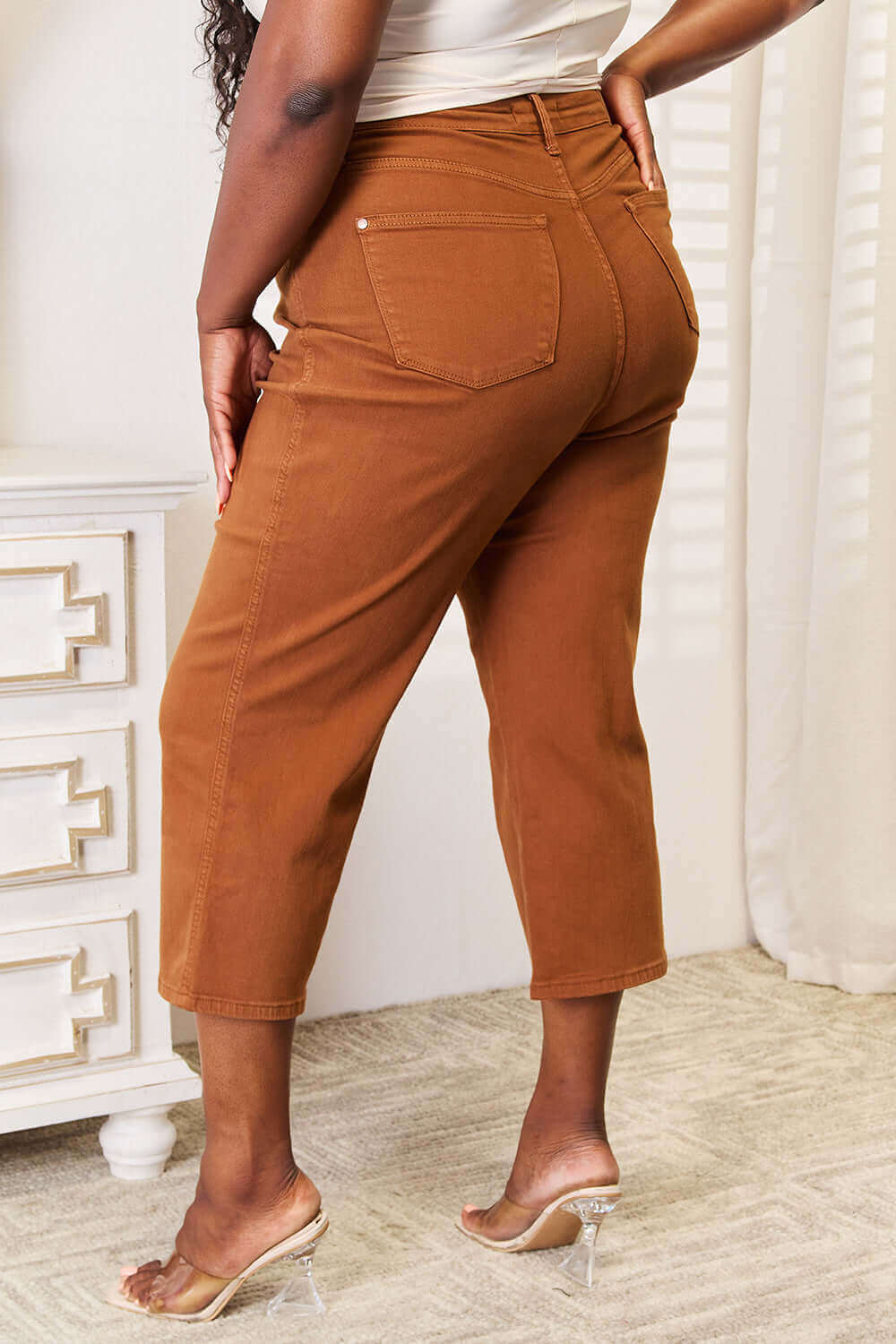 Woman wearing brown tummy control Judy Blue Jeans cropped at the ankle with a straight-leg cut, styled with heeled sandals.