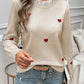 Woman wearing Devine Lace Detail Heart Long Sleeve Sweater with red heart details and lace neckline, paired with blue jeans.