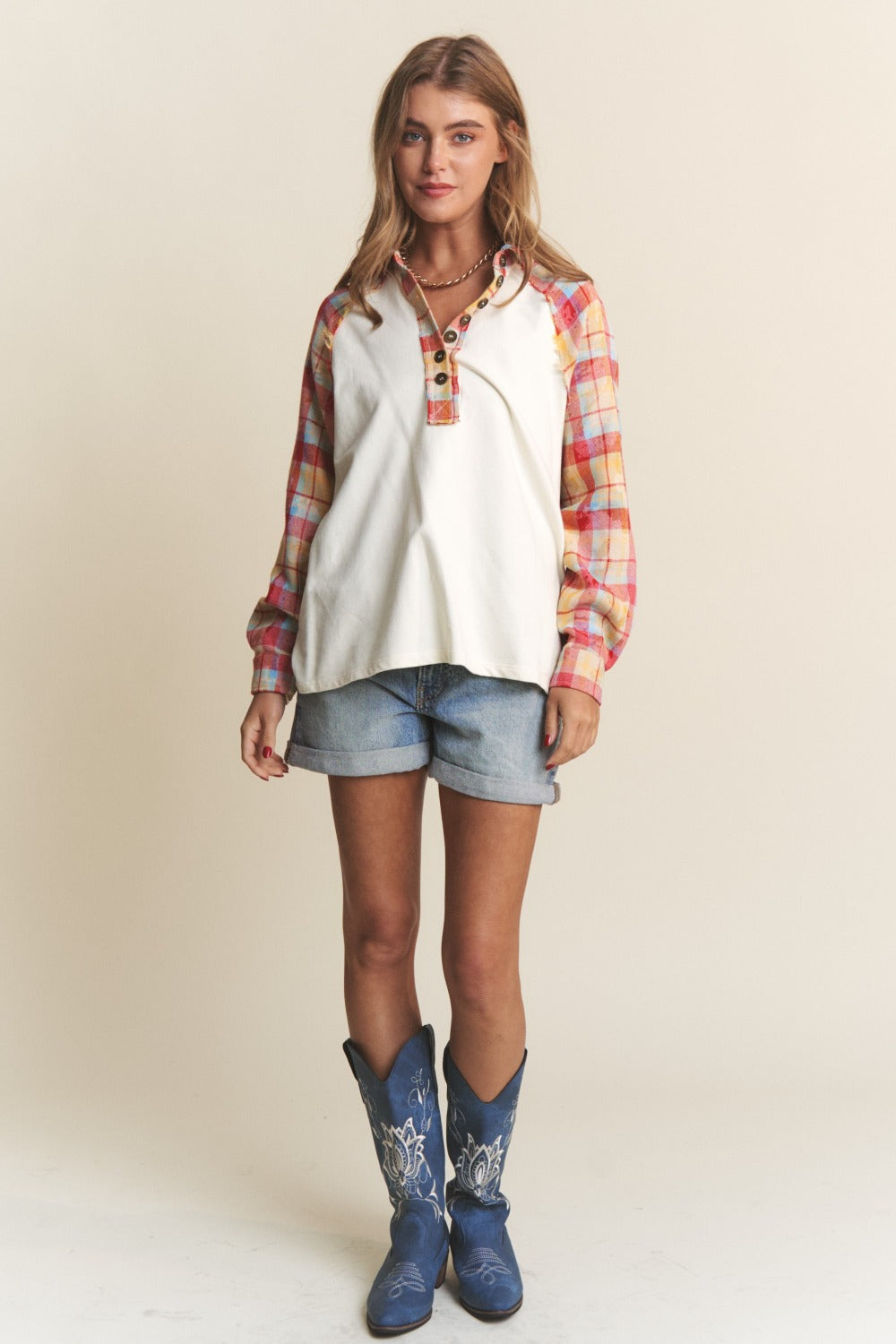 Woman wearing J.NNA Plaid Contrast Button Down Henley Top with denim shorts and cowboy boots, showcasing a chic casual style.