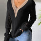 Woman wearing Bella Road Openwork V-Neck Long Sleeve Sweater in black with stylish design and casual jeans.