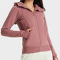 Woman modeling the Millennia Zip Up Seam Detail Hooded Sports Jacket in mauve, showcasing a stylish and comfy design.