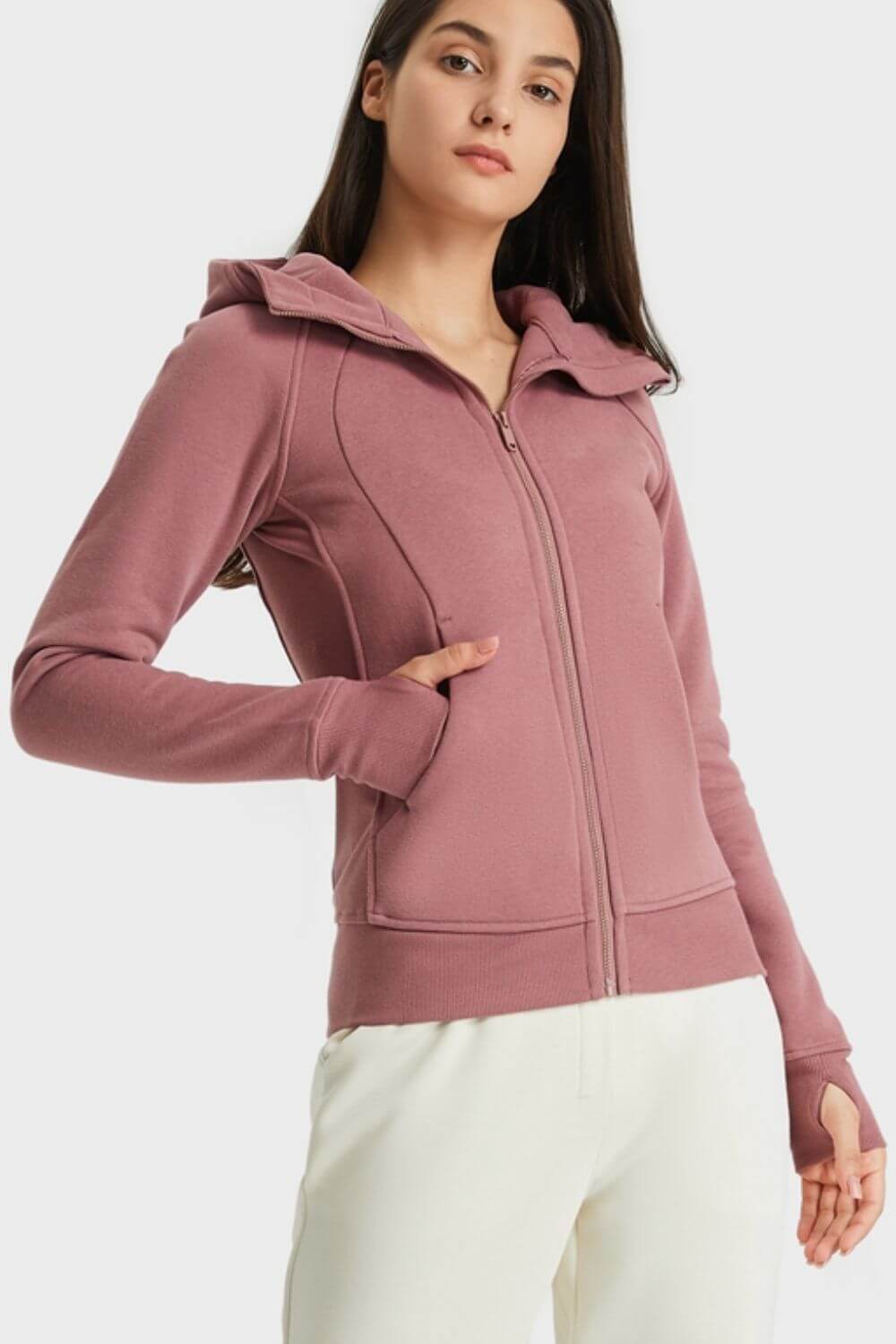 Woman modeling the Millennia Zip Up Seam Detail Hooded Sports Jacket in mauve, showcasing a stylish and comfy design.