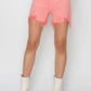 High Rise Distressed Denim Shorts in coral worn with white lace top and boots