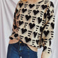 Woman wearing Bella Road Heart Contrast Long Sleeve Dropped Shoulder Sweater with heart design and jeans