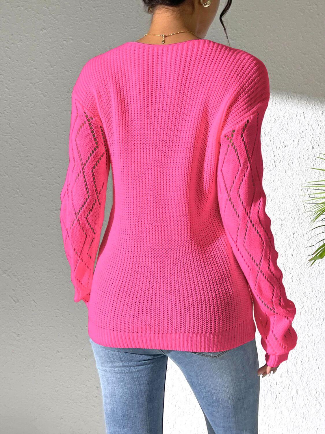 Stylish pink openwork long sleeve sweater with jeans, showcasing back view and intricate sleeve design. Cozy and fashionable look.