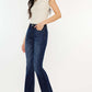 Woman wearing Kancan mid-rise slim flare jeans in dark stone wash, showcasing a chic and versatile denim style.