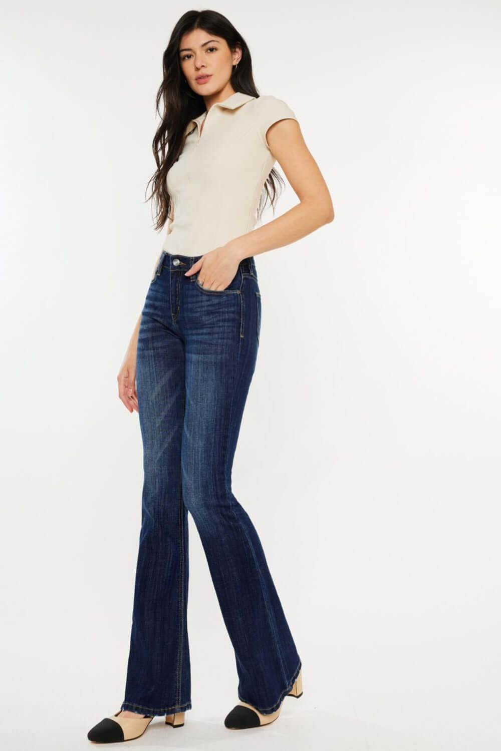 Woman wearing Kancan mid-rise slim flare jeans in dark stone wash, showcasing a chic and versatile denim style.