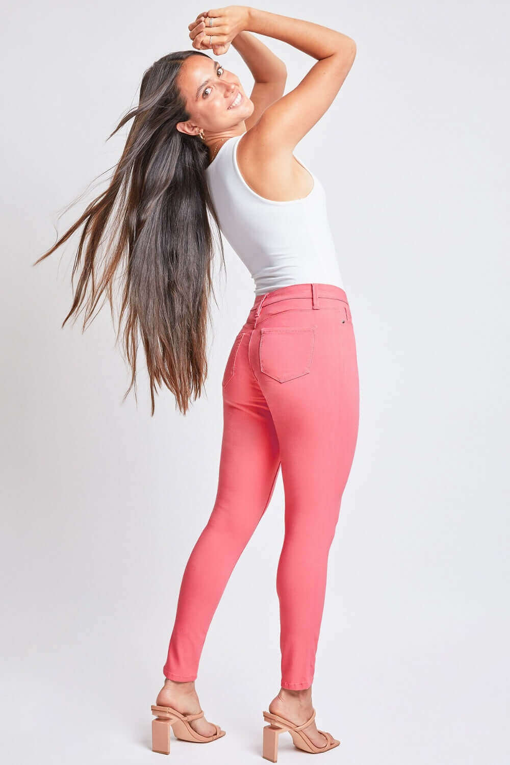 Woman wearing Hyperstretch Mid-Rise Skinny Jeans by YMI Jeans in a stylish pose, showcasing the comfortable and stretchy fit, perfect for any occasion.