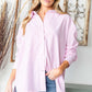 Woman wearing a First Love Full Size Striped Button Down High-Low Hem Shirt in pink and white stripes with blue jeans.