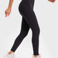 Woman in black Millennia Highly Stretchy Yoga Leggings with wide waistband, showcasing comfort and style for workouts.