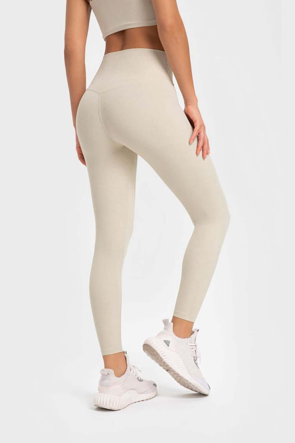 Model showing off Millennia Highly Stretchy Wide Waistband Yoga Leggings in light beige, perfect for a flexible workout.