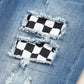 Checkered patchwork on distressed denim jeans with frayed details. Trendy mid-waist jeans for a stylish and edgy look.