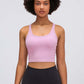 Model showcasing the Millennia Racerback Sports Bra in soft pink, perfect for yoga or sporty activities.