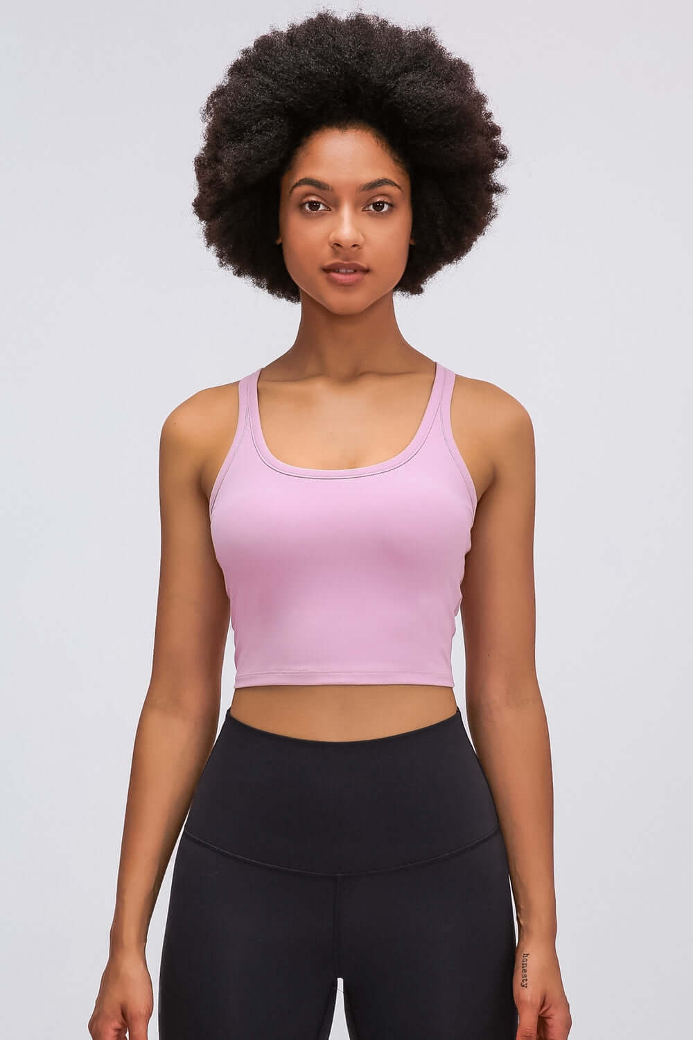 Model showcasing the Millennia Racerback Sports Bra in soft pink, perfect for yoga or sporty activities.