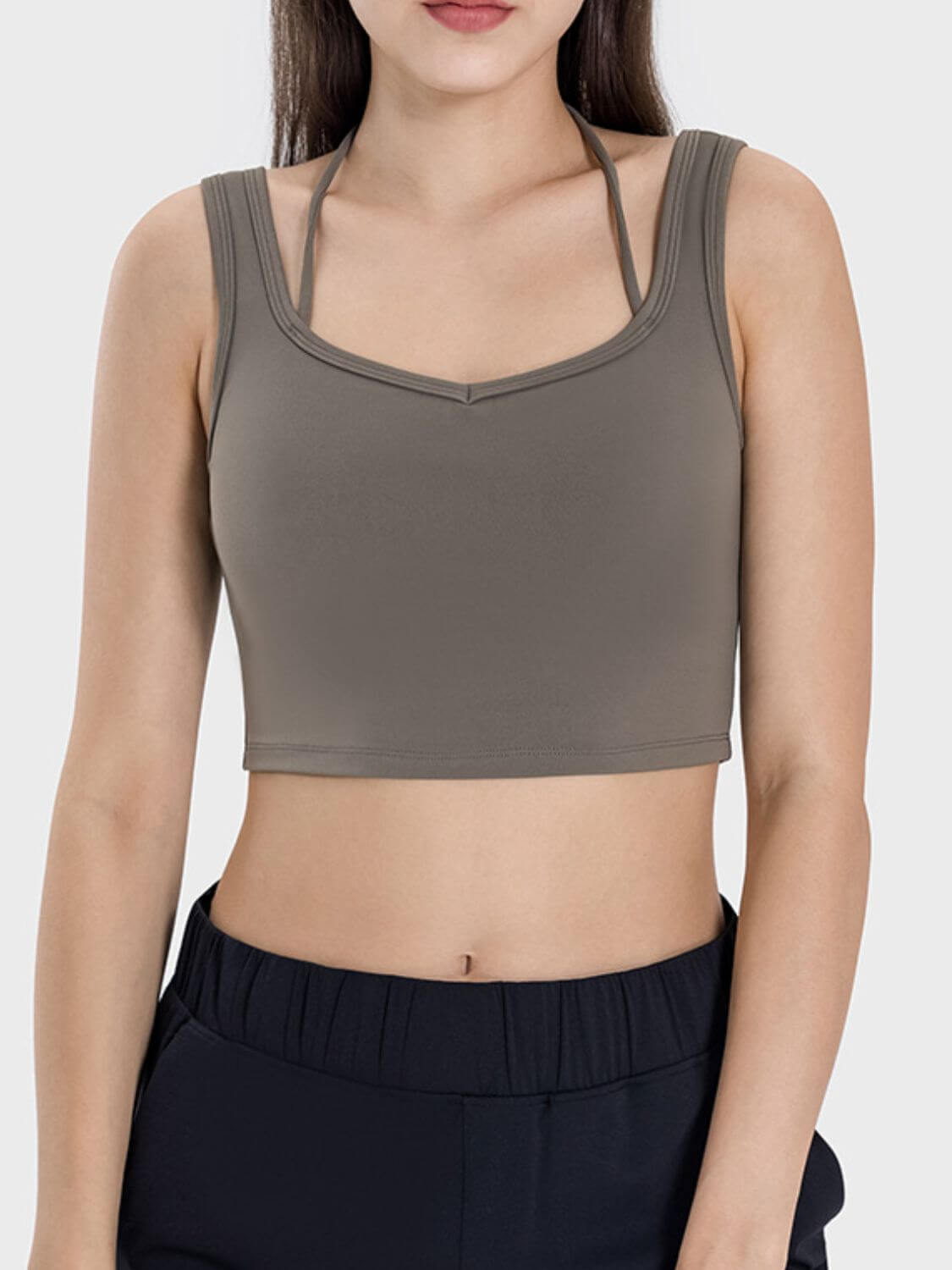 Stylish woman wearing a crisscross square neck active tank, perfect for workouts and casual errands.