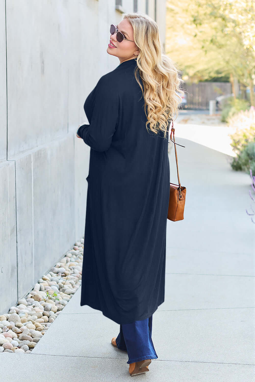 Woman wearing Open Front Long Sleeve Cover Up in black, walking outdoors, back view