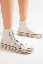 Stylish white multi-buckle platform sneakers with studded details, perfect for edgy fashion lovers.